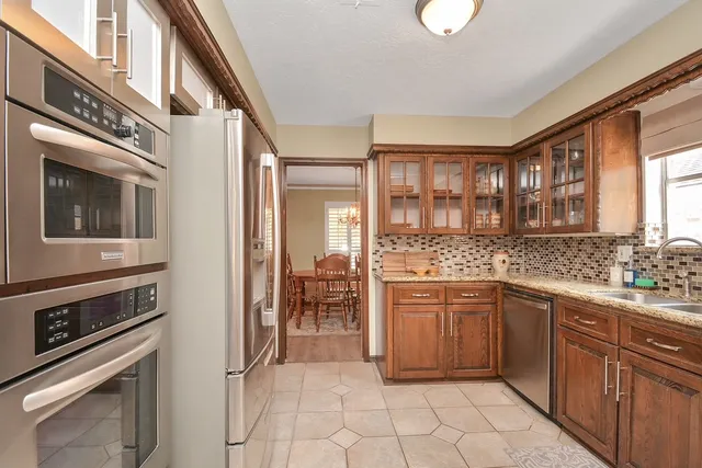 a kitchen with stainless steel appliances granite countertop a refrigerator stove and sink