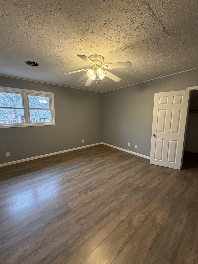 2 Hickory Lane Metropolis, IL 62960 - Photo 14 of 20 an empty room with wooden floor chandelier fan and windows