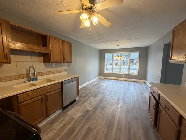 a kitchen with stainless steel appliances a refrigerator and a wooden floor