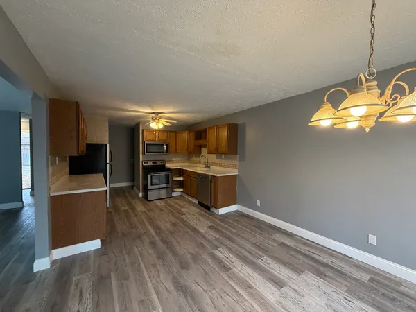 a kitchen with stainless steel appliances granite countertop a stove and wooden floor