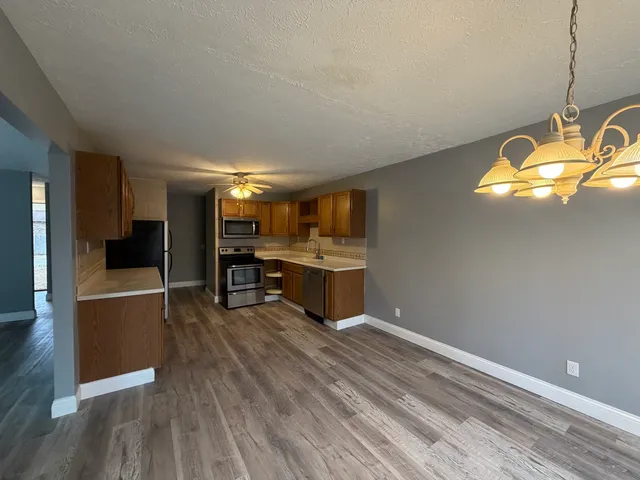 a kitchen with stainless steel appliances granite countertop a stove and wooden floor