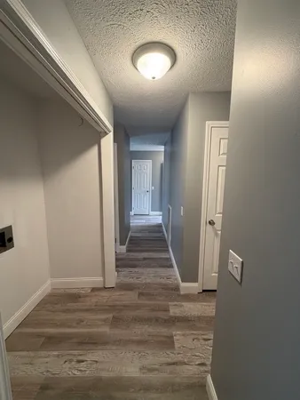 a view of a hallway with wooden floor and staircase