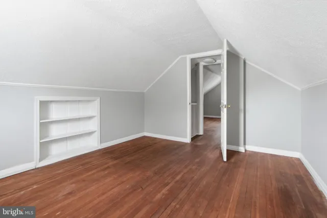 an empty room with wooden floor & closet