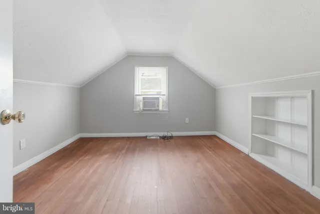 an empty room with wooden floor and window