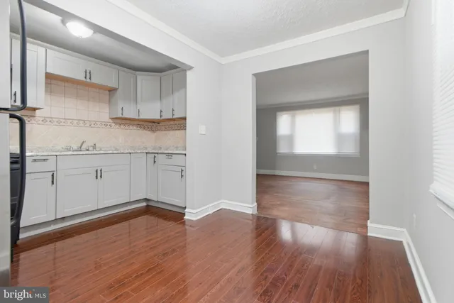 a kitchen with wooden floors and white cabinets