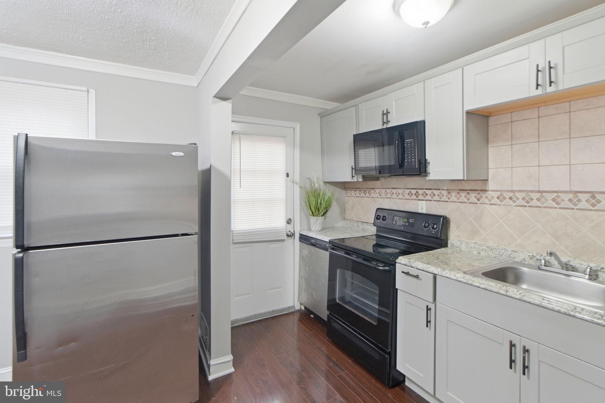5330 Dogwood Road Woodlawn, MD 21207 - Photo 7 of 38 a white refrigerator freezer sitting inside of a kitchen