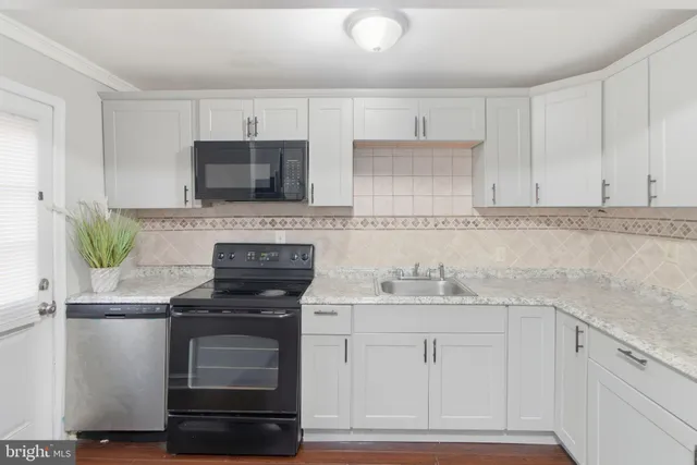 a kitchen with white cabinets and appliances