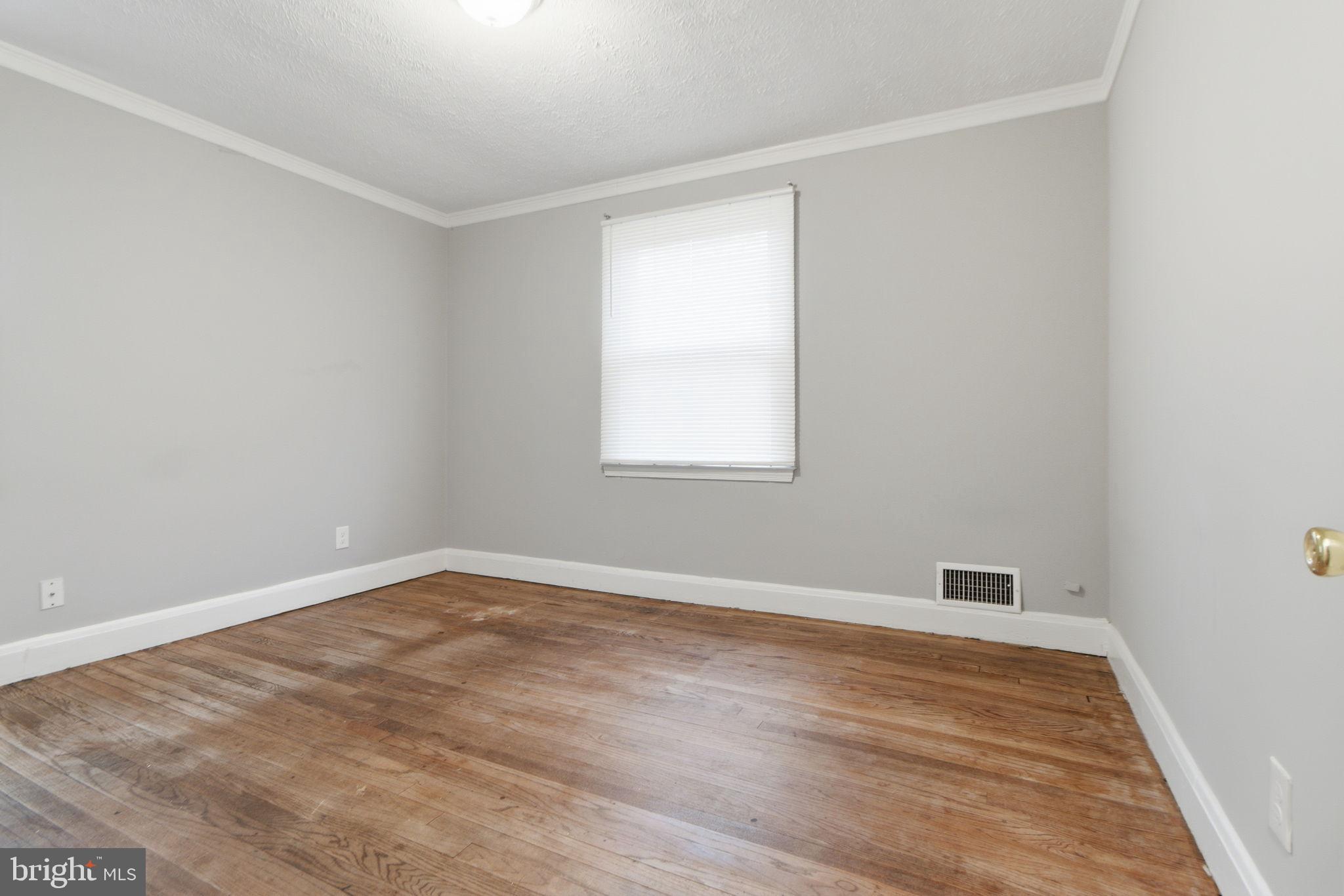 5330 Dogwood Road Woodlawn, MD 21207 - Photo 10 of 38 a view of an empty room with wooden floor and a window