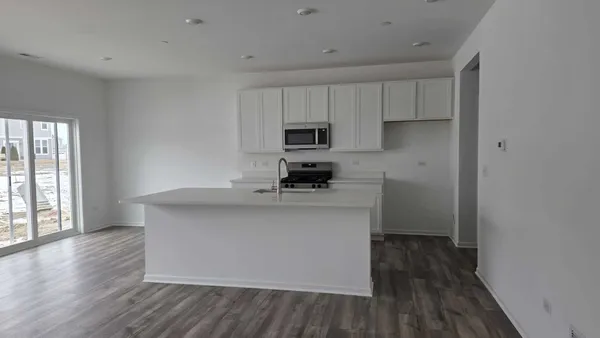 a kitchen with stainless steel appliances a sink stove and wooden floor