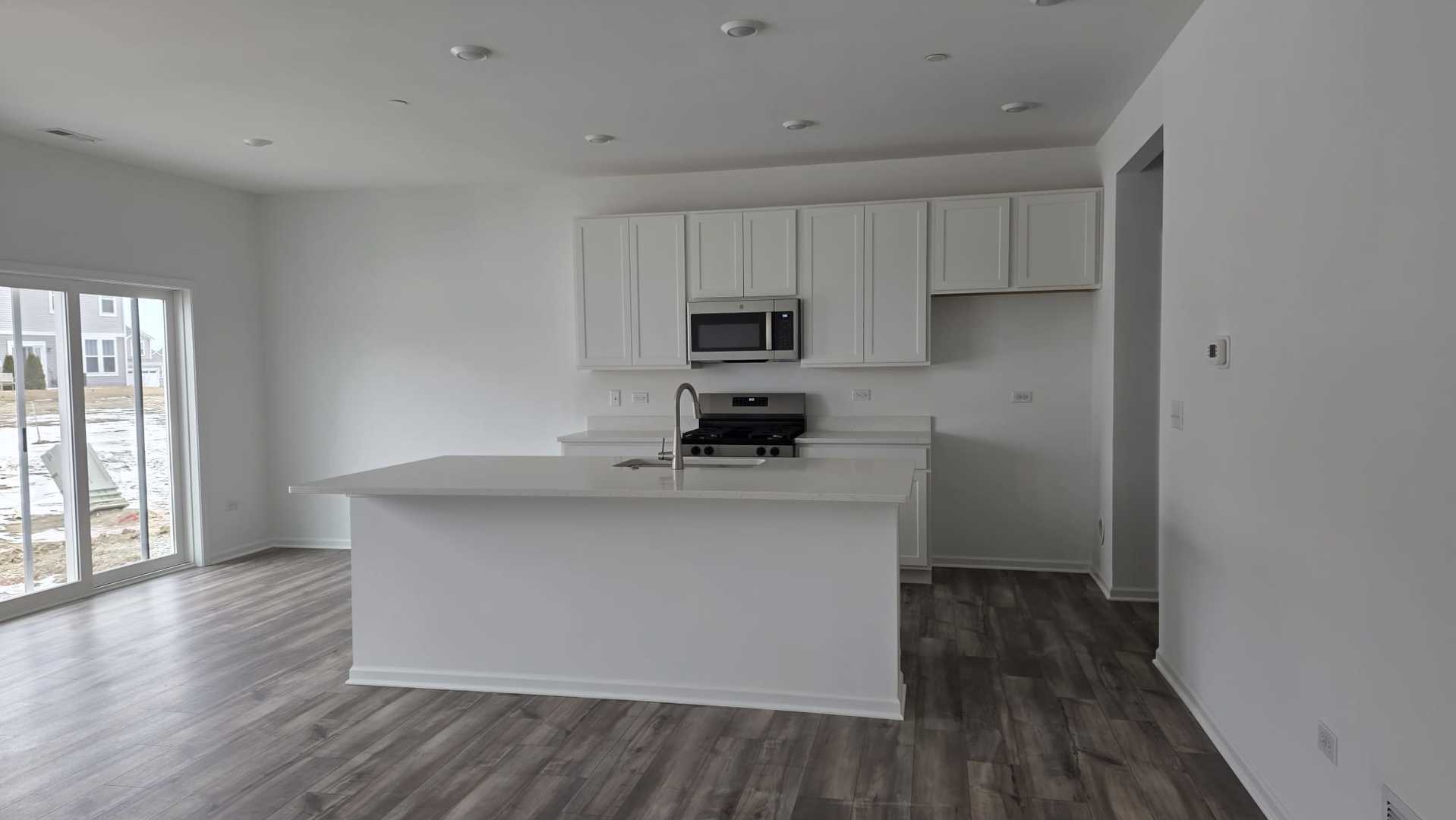 246 Cooney Way Oswego, IL 60543 - Photo 3 of 13 a kitchen with stainless steel appliances a sink stove and wooden floor