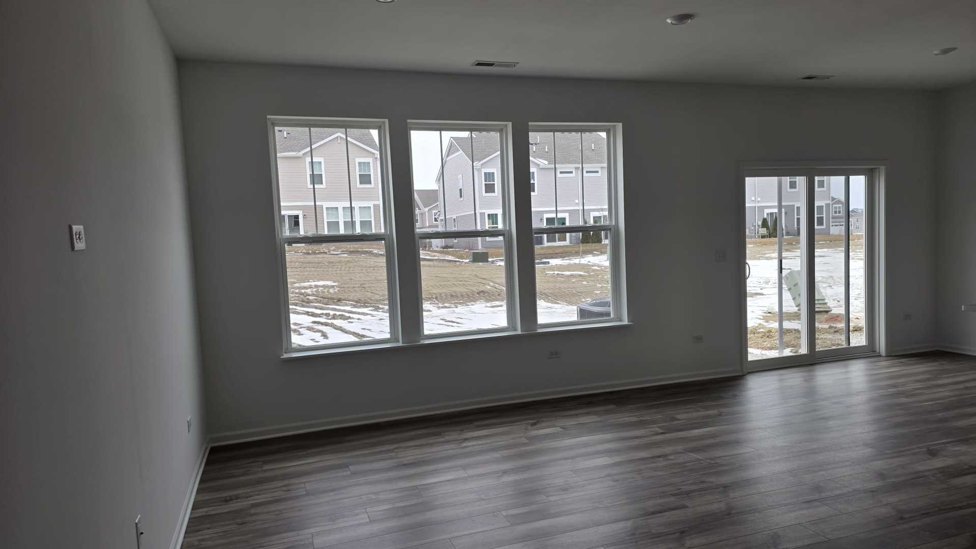246 Cooney Way Oswego, IL 60543 - Photo 4 of 13 a view of an empty room with wooden floor and a window