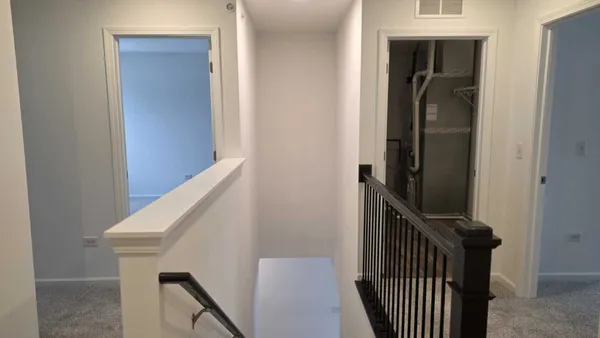 a view of a hallway with wooden floor and entryway