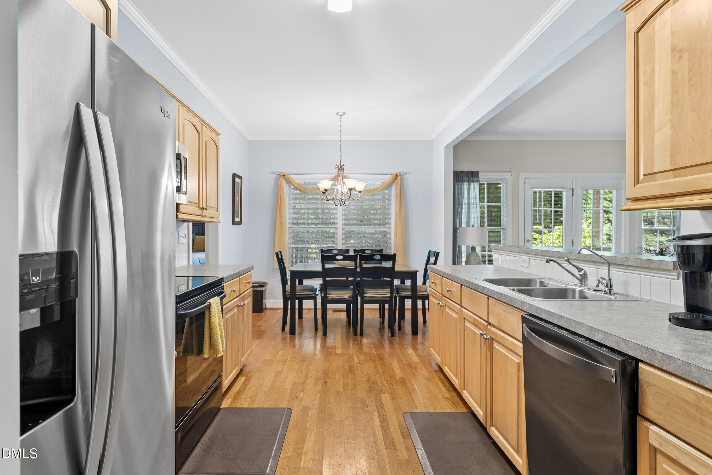 7619 Whitaker Drive Summerfield, NC 27358 - Photo 16 of 25 a kitchen with granite countertop a refrigerator a sink a dining table and chairs