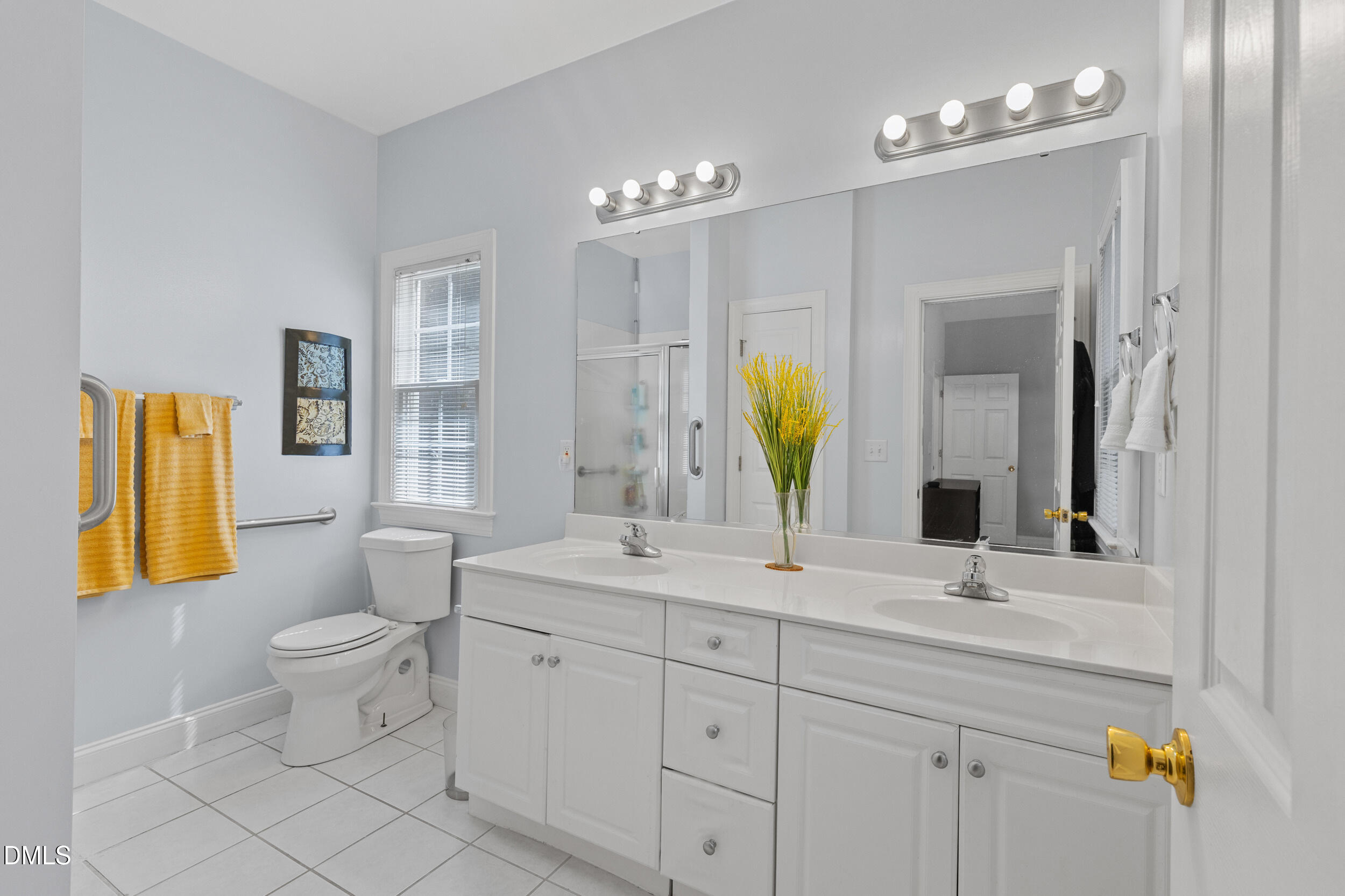 7619 Whitaker Drive Summerfield, NC 27358 - Photo 21 of 25 a bathroom with a double vanity sink and a mirror