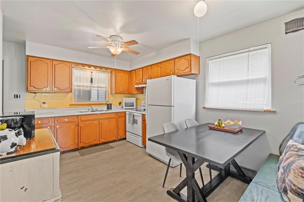 2184 Dime Road Vandergrift, PA 15690 - Photo 5 of 25 a kitchen with stainless steel appliances granite countertop a stove a refrigerator a sink a dining table and chairs with wooden floor