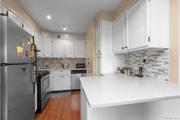 a kitchen with granite countertop a sink stainless steel appliances and cabinets