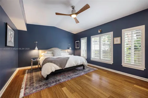 a bedroom with a bed lamp and a large window