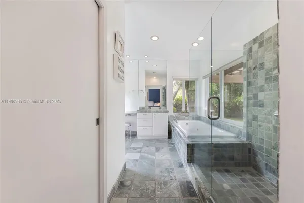 a large bathroom with a tub shower and sink