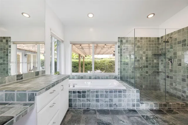 a bathroom with a granite countertop sink and large window