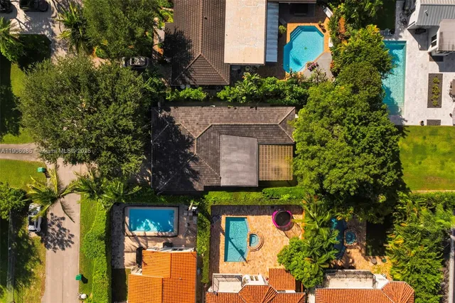 an aerial view of a house with a yard and fountain in front of it
