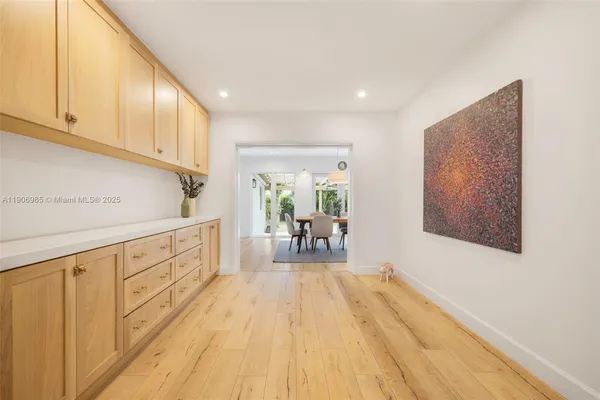 a kitchen with white cabinets and wooden floor