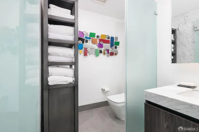 a bathroom with a granite countertop toilet and a sink