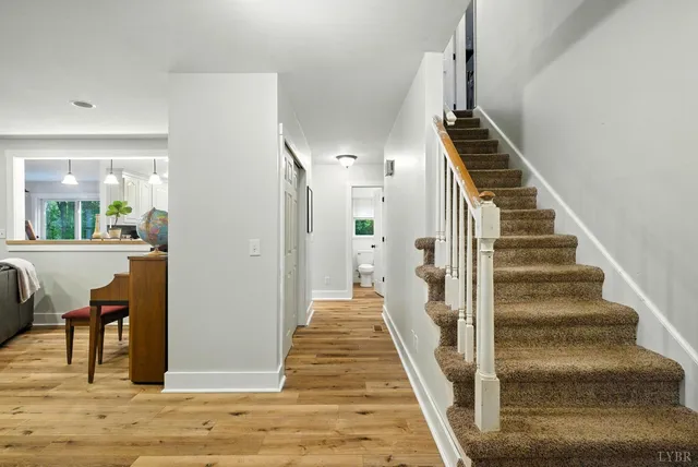 a view of a hallway with wooden floor and stairs