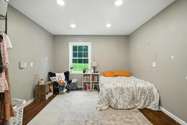 a bedroom with furniture and a large window