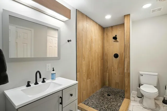 a bathroom with a sink a toilet and shower
