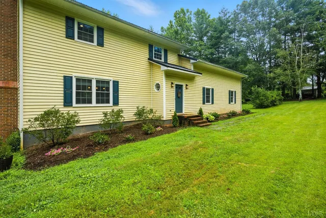 a backyard of a house with yard and outdoor seating