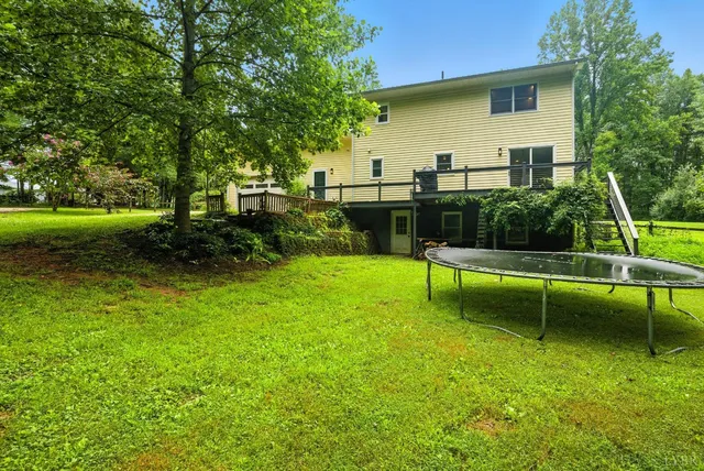 a view of house with swimming pool and a bench