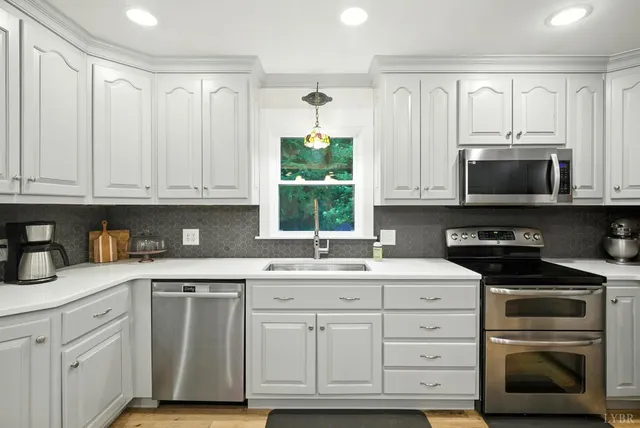 a kitchen with white cabinets and appliances