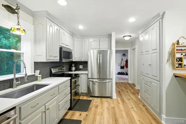 a kitchen with white cabinets and stainless steel appliances