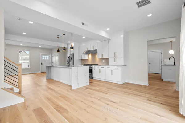a large kitchen with kitchen island a refrigerator a sink dishwasher with a dining table and chairs