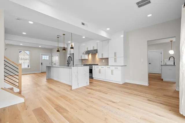 a large kitchen with kitchen island a refrigerator a sink dishwasher with a dining table and chairs