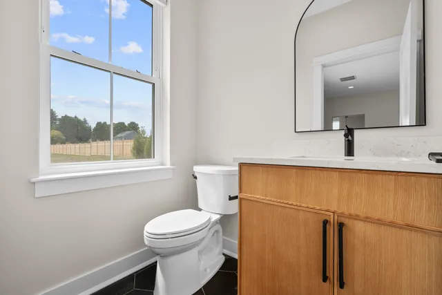 a bathroom with a granite countertop sink toilet and mirror