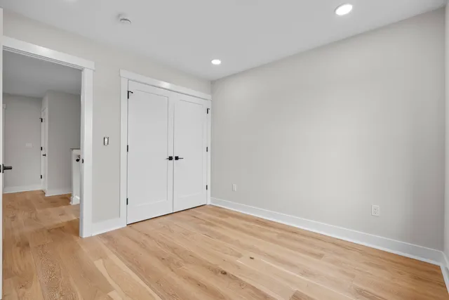 a view of empty room with wooden floor