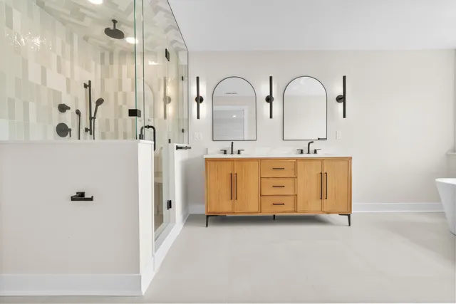 a bathroom with a double vanity sink a mirror and a shower
