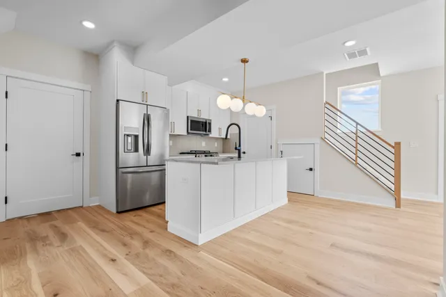 a kitchen with white cabinets and stainless steel appliances