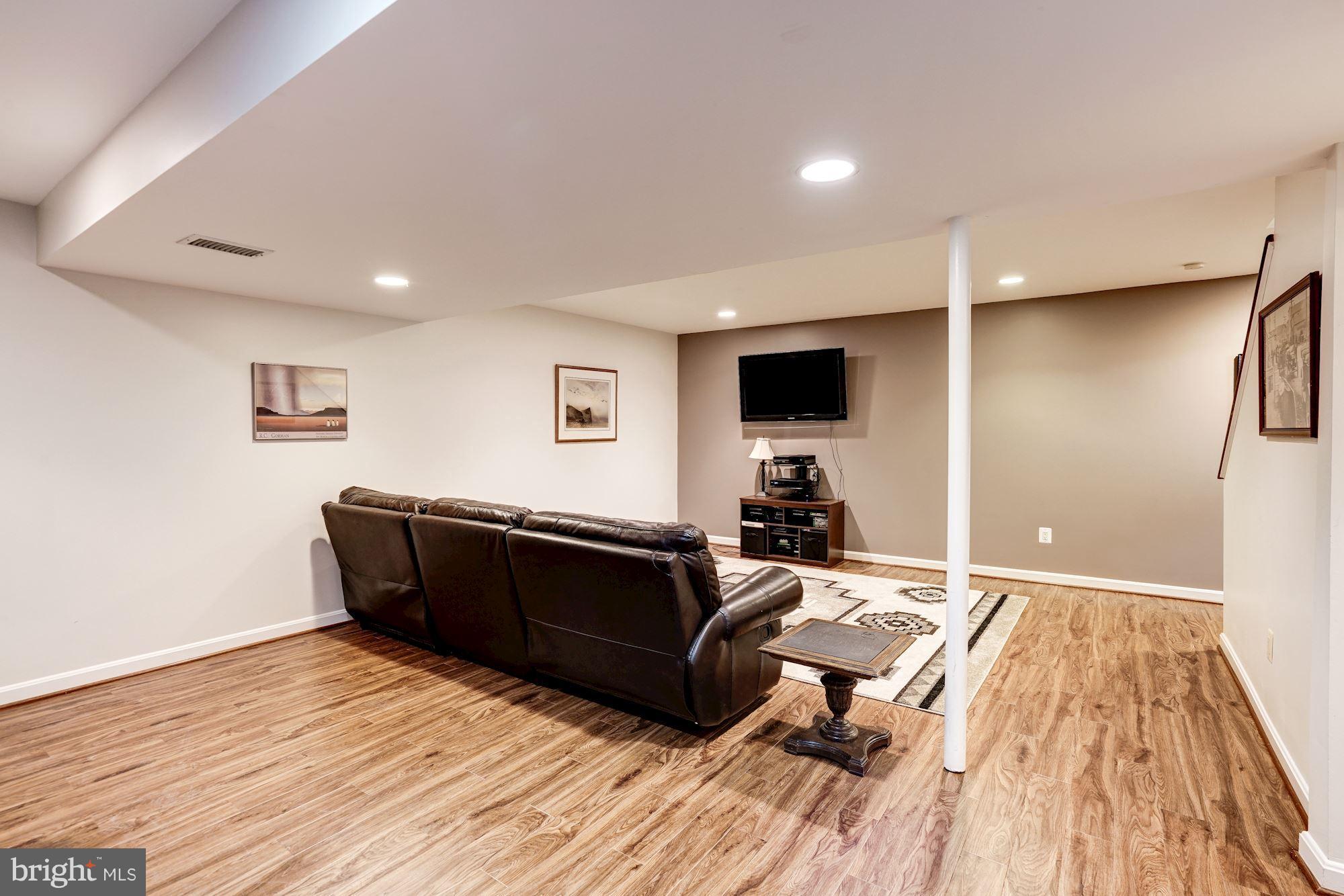 2104 Salt Kettle Way Reston, VA 20191 - Photo 20 of 29 a living room with a couch and a wooden floor