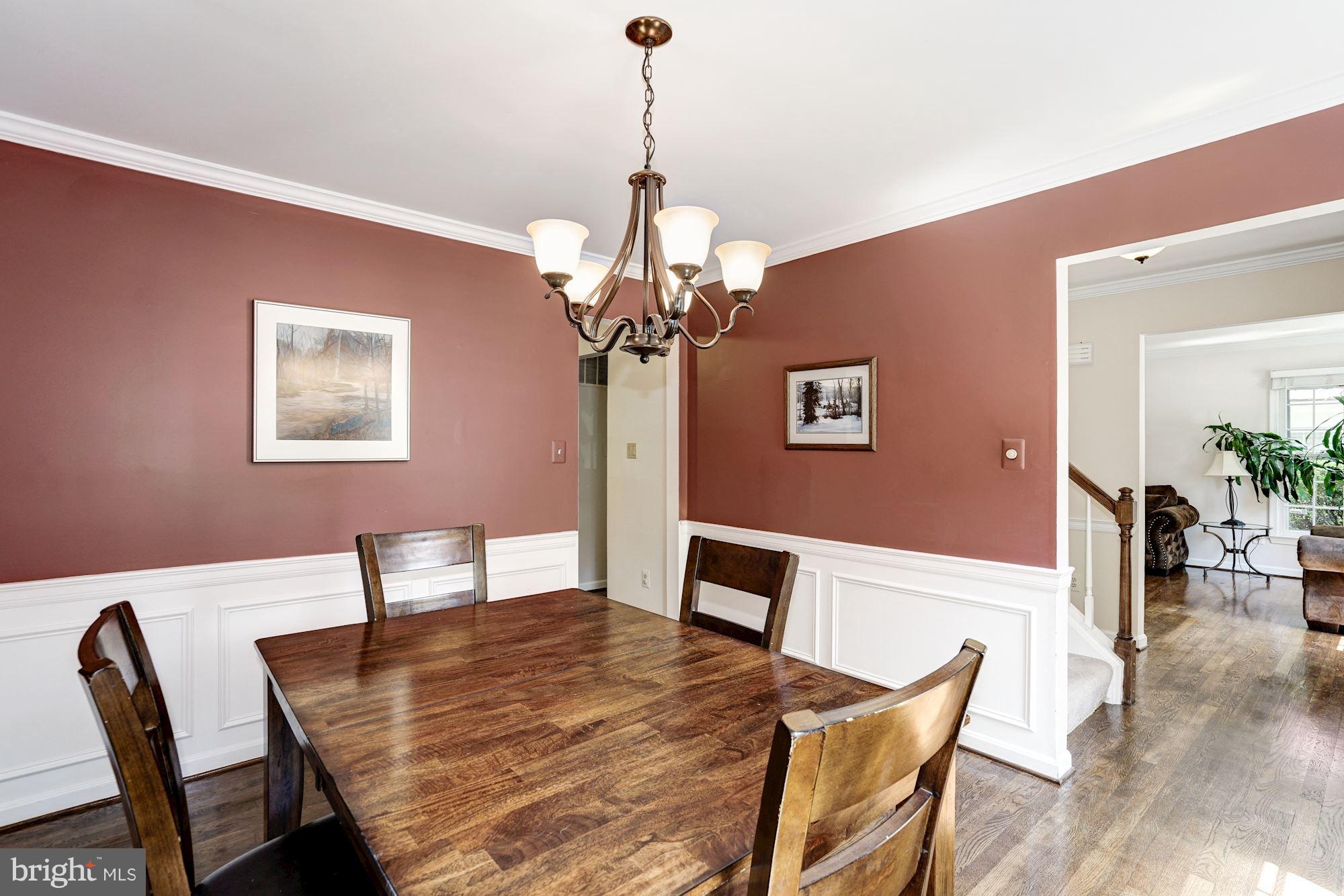 2104 Salt Kettle Way Reston, VA 20191 - Photo 5 of 29 a dining room with wooden floor a chandelier a wooden table and chairs