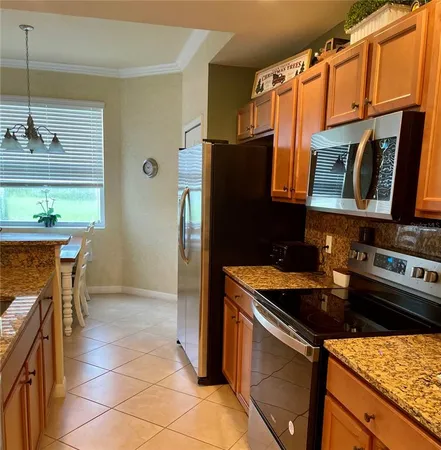 a kitchen with stainless steel appliances granite countertop a refrigerator and a stove