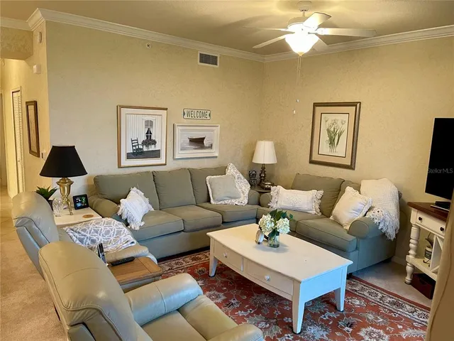 a living room with furniture a flat screen tv and a table