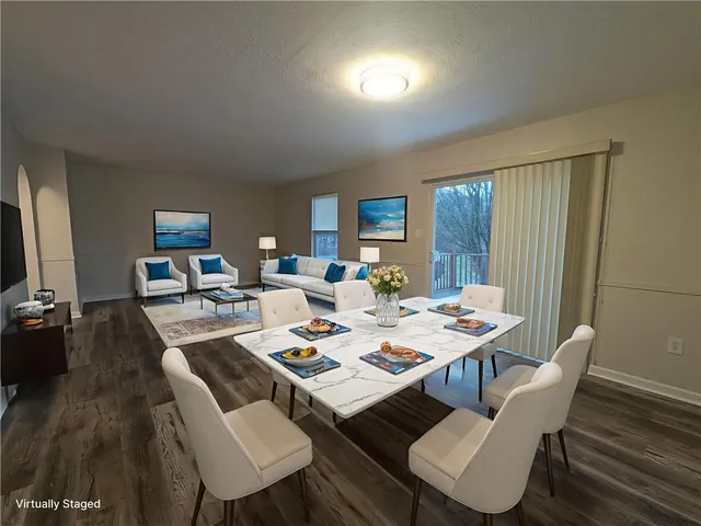a dining room with wooden floor a glass table and chairs