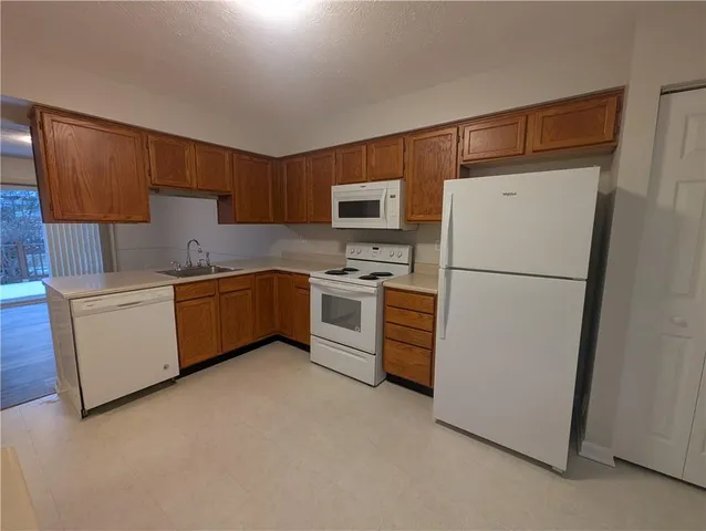 a kitchen with a refrigerator a stove top oven a sink and cabinets