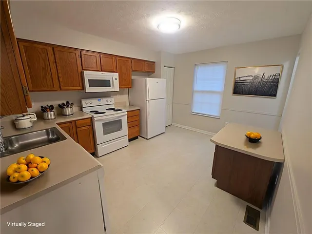 a kitchen with stainless steel appliances a stove a refrigerator a sink a stove with white cabinets