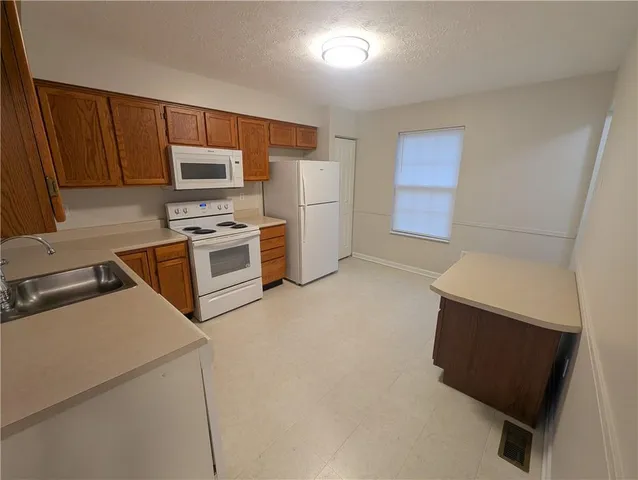 a kitchen with a refrigerator stove and microwave
