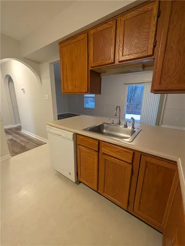 a kitchen with stainless steel appliances granite countertop a sink refrigerator and cabinets