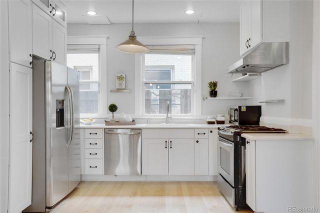 a kitchen with stainless steel appliances a stove a sink and a refrigerator