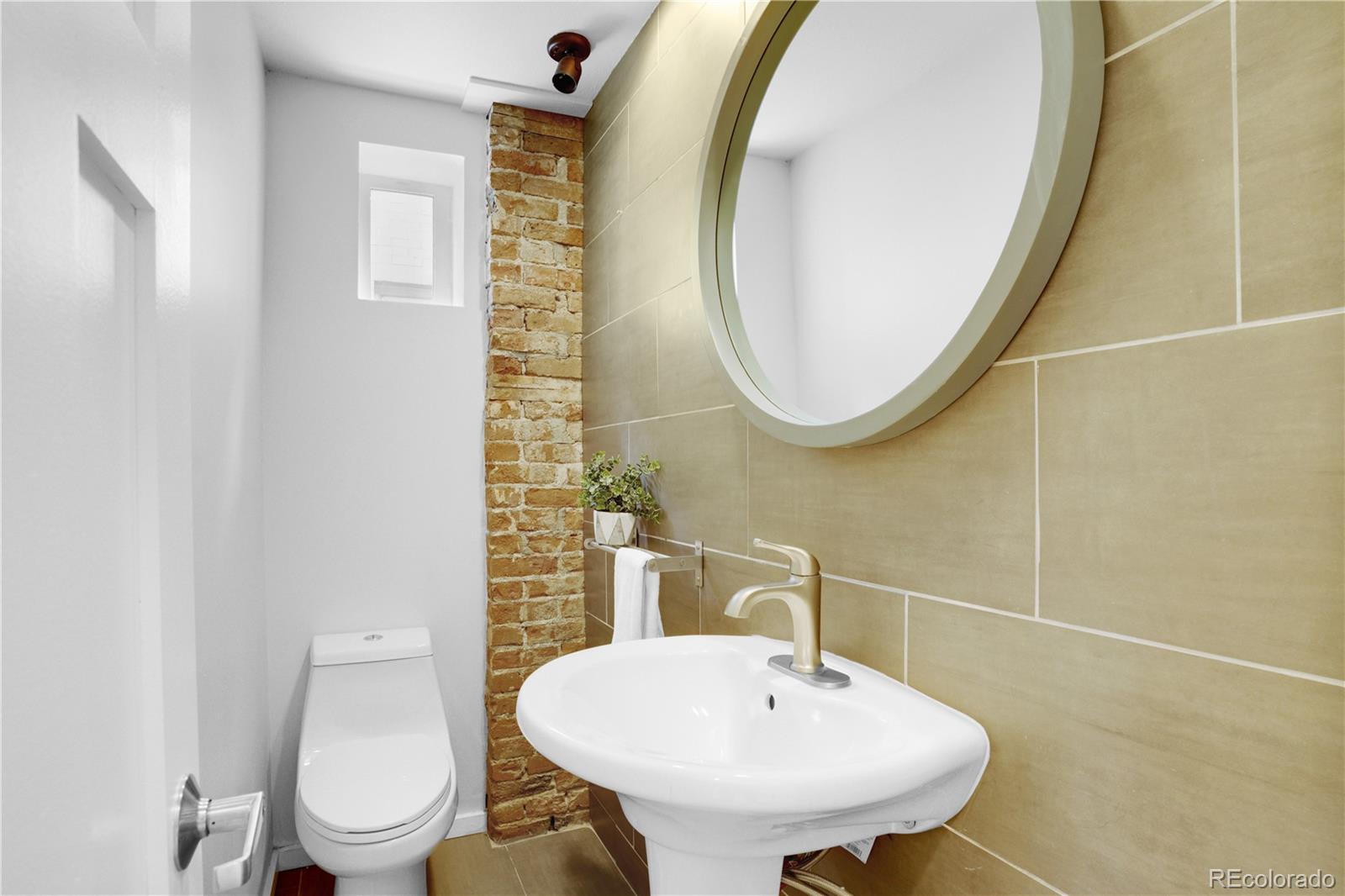 1283 Madison Street Denver, CO 80206 - Photo 14 of 34 a bathroom with a toilet sink and mirror